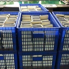 Finished folding cartons stacked in crates on the factory floor